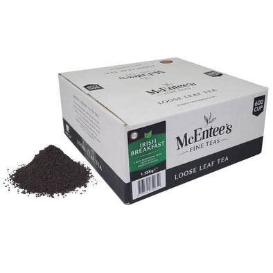 Box of McEntee's Fine Teas loose leaf tea with scattered tea leaves on a white background