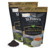 Two packages of McEntee's Fine Teas Loose Leaf Tea Master Blend with tea leaves and a cup on a white background.