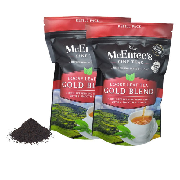 Two packages of McEntee's Fine Teas Loose Leaf Gold Blend with tea powder on a white background